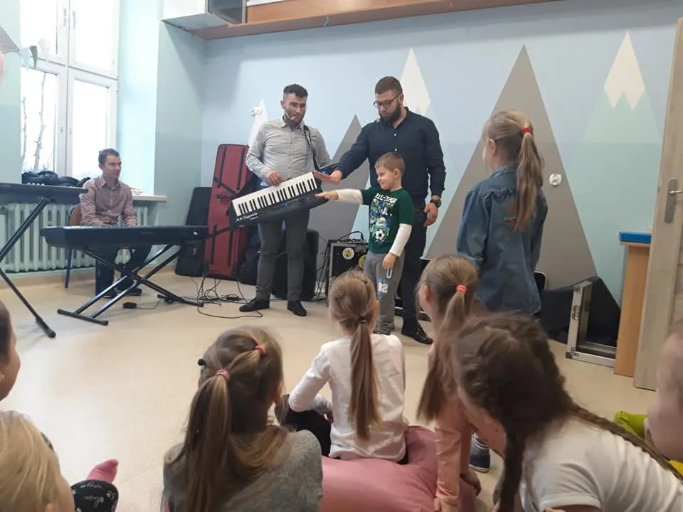 Obraz przedstawia naszych wychowanków podczas audycji muzycznej. Na zdjęciu możemy ujrzeć różnego rodzaju instrumenty muzyczne.