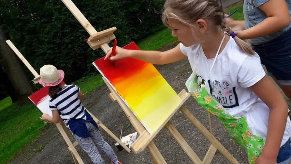 Obraz przedstawia malujące dzieci przy użyci akryli.