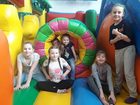 Obraz przedstawia wychowanków SPWD podczas ferii. Na zdjęciu widzimy dzieci na dmuchanym torze przeszkód.