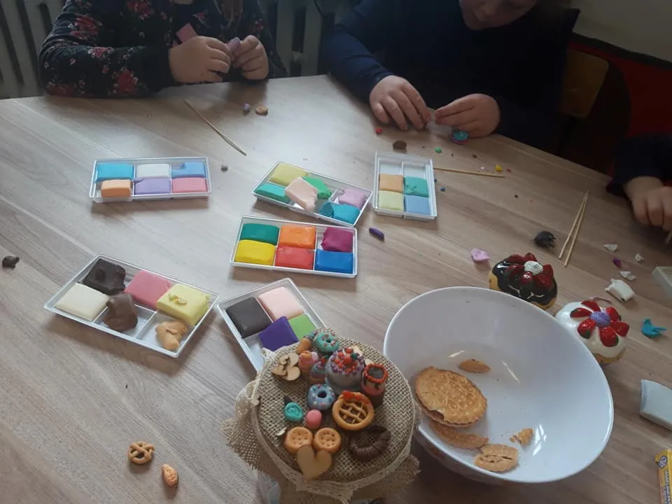 Obraz przedstawia modelinowe wypieki naszych wychowanków. Na zdjęciu możemy ujrzeć proces powstawania modelinowych ciastek.