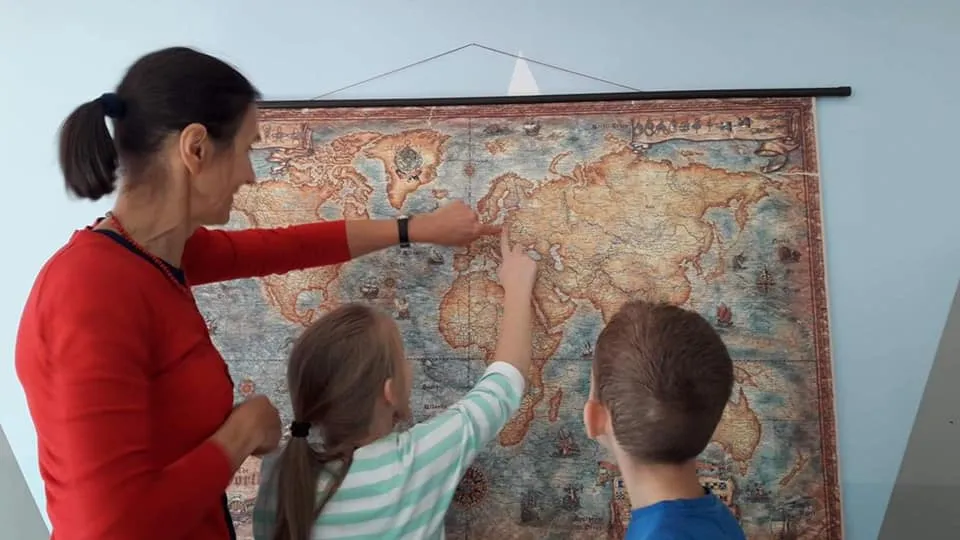 Obraz przedstawia naukę geografii w placówce przy użyciu mapy świata.