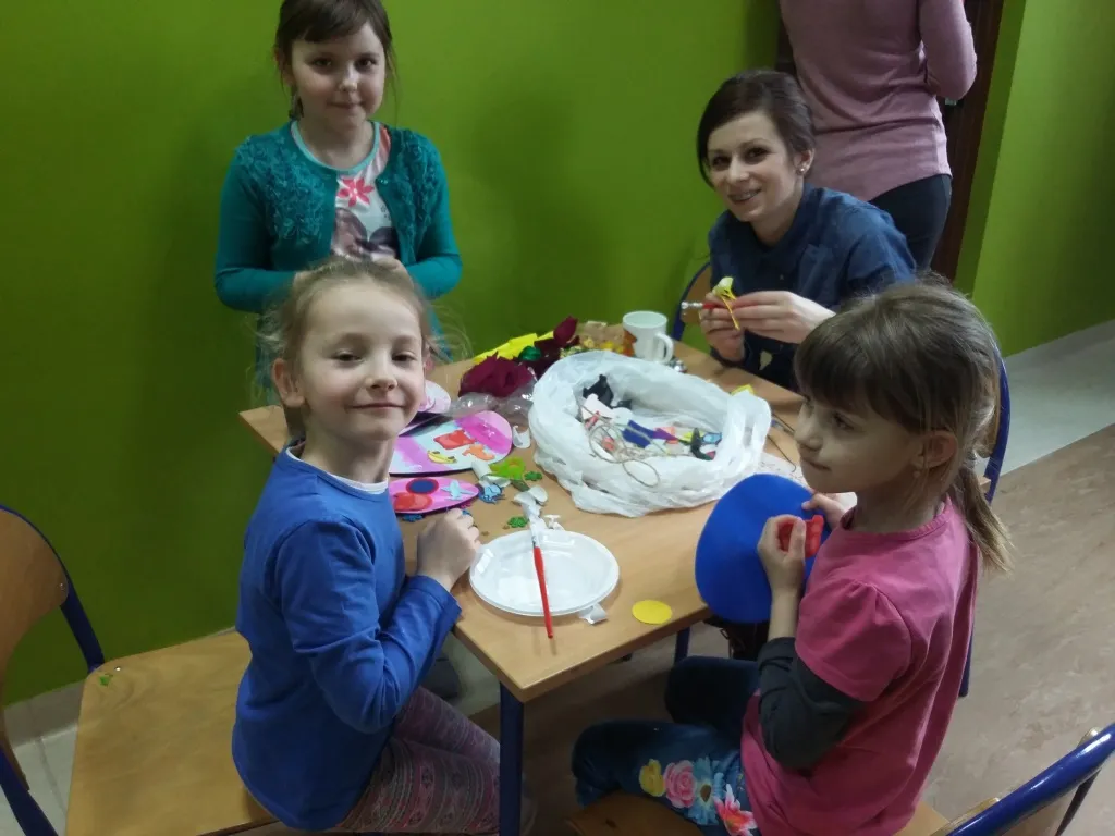 Zdjęcie przedstawia dzieci z placówki tworzące dekoracje świąteczne.