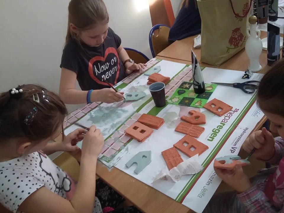 Na zdjęciu widnieją dzieci z placówki tworzące kolejne rękodzieła, tym razem przy pomocy rzeźbiarstwa.