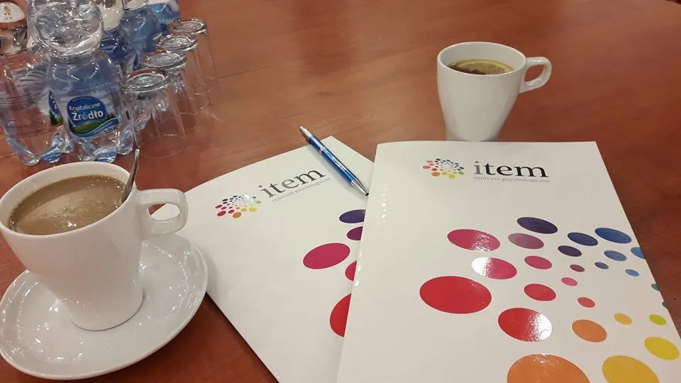 Obraz przedstawia kubek z kawą, herbatą, wodę wraz z szklankami oraz książeczki item.