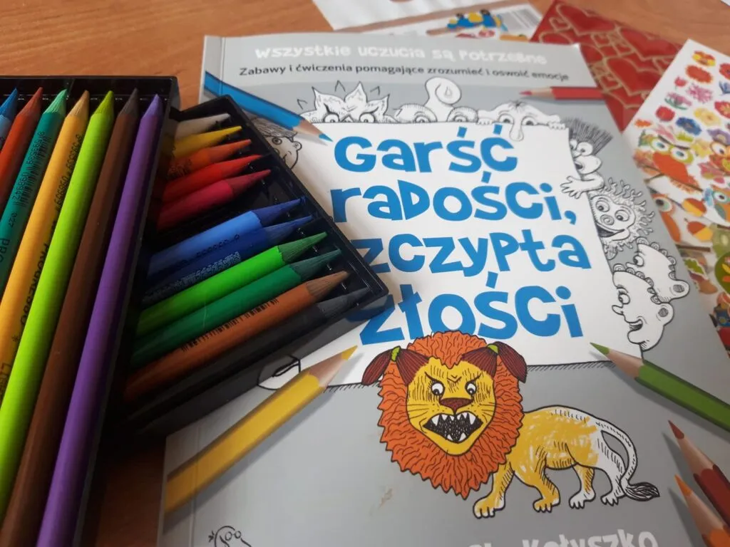 Obraz przedstawia kredki oraz kolorowanki.