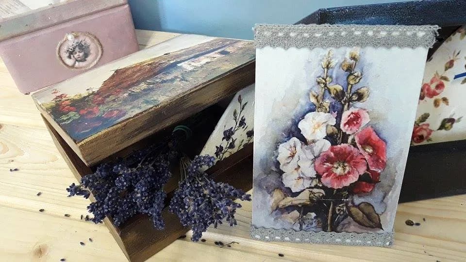 Zdjęcie przedstawia rękodzieła takie jak skrzynie oraz obraz kwiatów udekorowany wstążkami.