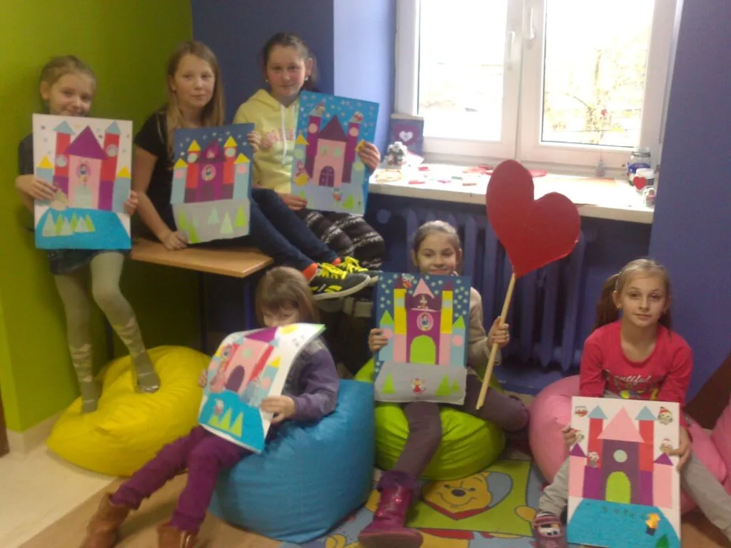 Zdjęcie przedstawia dzieci z placówki trzymające ich dzieła powstałe w ramach akcji "Radłów dzieli się miłością!"