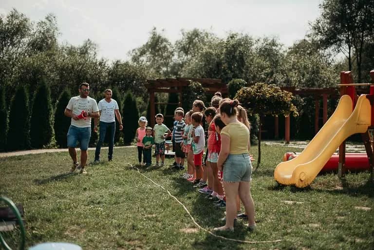 Obraz przedstawia wychowanków uczestniczących w różnego rodzaju konkursach, konkurencjach czy zabawach zorganizowanych przez animatorów.