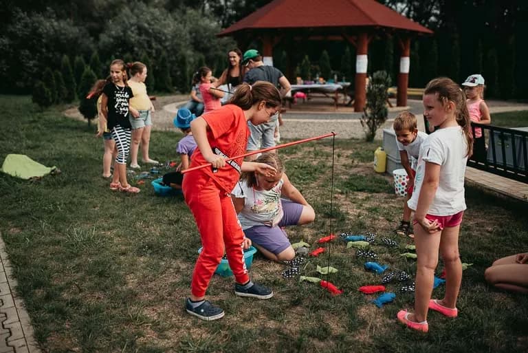 Obraz przedstawia wychowanków uczestniczących w różnego rodzaju konkursach, konkurencjach czy zabawach zorganizowanych przez animatorów.