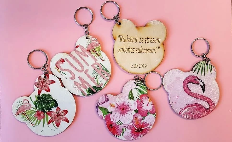 Obraz przedstawia prace wykonane przez wychowanków SPWD podczas warsztatów artystycznych. Na zdjęciu możemy ujrzeć bryloczki wykonane z drewna, pomalowane w m.in. kwiatki na których napisane jest "Radzenie ze stresem zakończ sukcesem!"